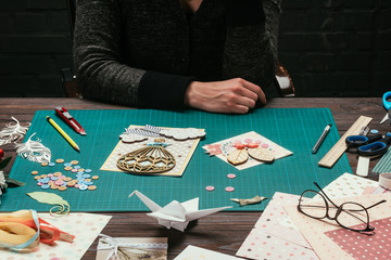 Fototapeta na wymiar cropped image of scrapbooking designer sitting at working table