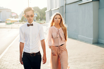 Outdoor summer evening portrait of stylish young couple walking on the street