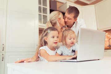 Young family of three using laptop while lying on carpet at home