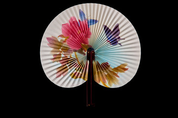 Closeup of Traditional Chinese fan on black background.