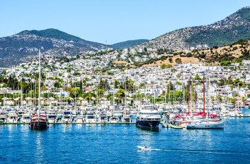 Fototapeta na wymiar Many yachts moored in the bay of Bodrum against the background of the city and mountains.