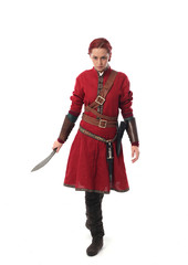 portrait of a red haired girl wearing medieval warrior outfit, studio background.