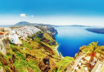Greece, Santorini. Amazing view from famous sunset point on island in Aegean sea -  Santorini over Oia - Ia village at the slope of volcano. Famous windmills and traditional greek white architecture.