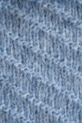 Blue knitted fluffy fabric texture. Hand knitting. Detailed warm yarn background.