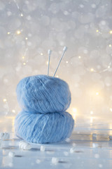 Two blue fluffy ball yarn and knitting needles. Christmas background.