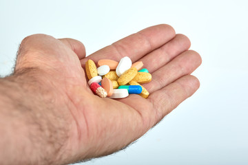 The hand of a man with different types of medication, Medicine pills or capsules in hand, palm. Colorful pills and medicines in the hand