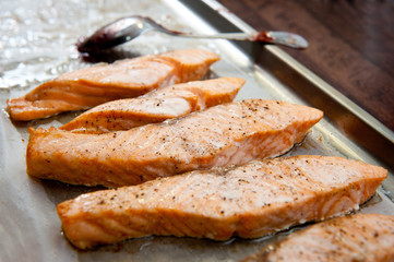 Salmon slices fried in a frying pan in sauce