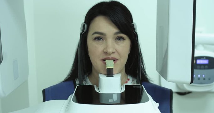 Modern dental clinic. Orthodontist tells the patient about the X-ray prints