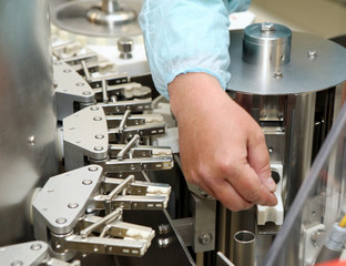 Repair and adjustment of medical equipment. Validation of the machine for the production of pharmaceutics. Man repairing a machine for the production of medicines. Repairs to the machine hands of men.