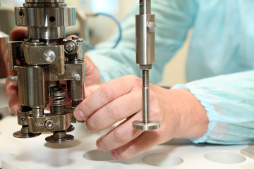 Repair and adjustment of medical equipment. Validation of the machine for the production of pharmaceutics. Man repairing a machine for the production of medicines. Repairs to the machine hands of men.