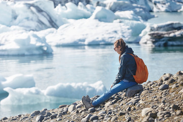 Fototapeta na wymiar Woman with backpack in Ice Lagoon in Iceland
