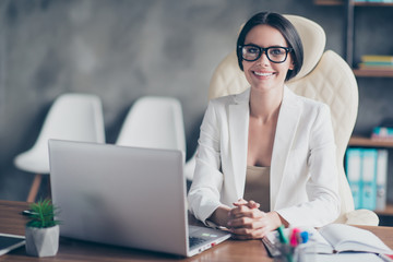 Portrait of confident smart successful beautiful businesswoman wearing white jacket, she is sitting...