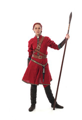 portrait of a red haired girl wearing medieval warrior outfit, studio background.