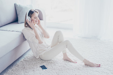 My mood depends on music! Charming relaxed careless beautiful woman is sitting on the floor,...