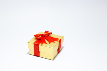 Gloden gift box with red bow on white background