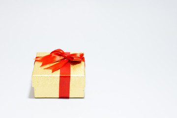 Gloden gift box with red bow on white background