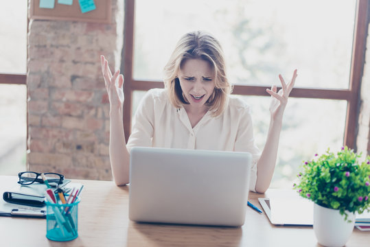 Something went wrong! Portrait of sad disappointed young worker, she has problems with her new project, she is sitting at the table