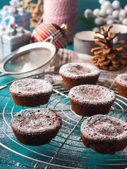 Chocolate chokecherry muffins with icing sugar. Winter christmas sweet food treat on dark green background