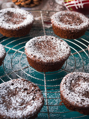 Chocolate chokecherry muffins with icing sugar. Winter christmas sweet food treat on dark green background