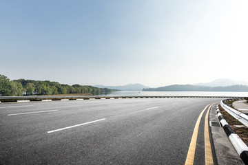 Fototapeta premium empty asphalt road with beautiful lake