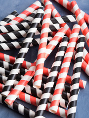 Obraz premium Red and black striped straws background. Party cocktail concept
