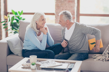 Guess what i have for you. Happy senior couple having anniversary day, bearded man prepared a packing gift box, holding present behind his back, to surprise his wife