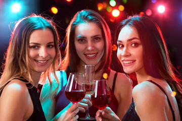 Happy young women with glasses of wine