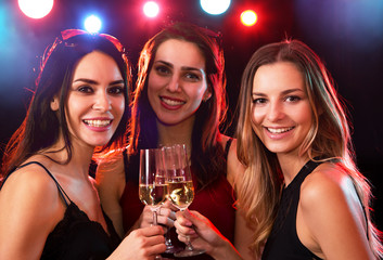 Happy young women with glasses of wine