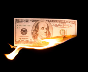 a hundred dollars burn in a fire on a black background