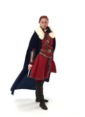 portrait of red haired girl wearing red medieval out fit, studio background.