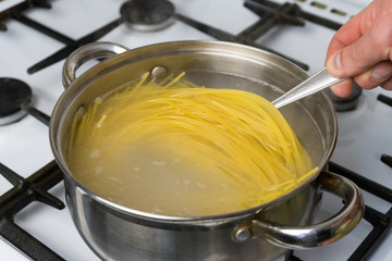 Spaghetti cooked in boiling water on a gas stove. The traditional Italian food.