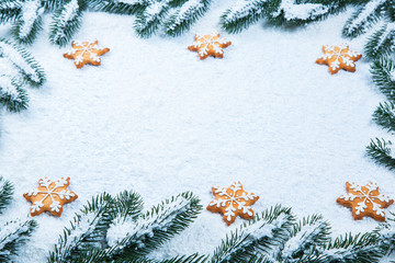 Christmas background with gingerbread cookies with snow and tree branches. Free space