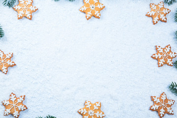 Christmas background with gingerbread cookies with snow and tree branches. Free space