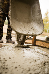 worker pours concrete mortar on a construction site