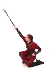 portrait of red haired girl wearing red medieval out fit, studio background.
