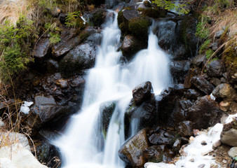 Fototapeta na wymiar Long exposed small waterfall in the mountains