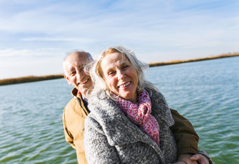 Portrait of senior couple embracing each other on a sunny autumn day.