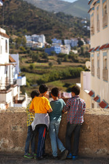 Fototapeta na wymiar Children looks at cityscape standing on the old street of Morocco