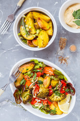Salad with baked vegetables and hummus, top view.
