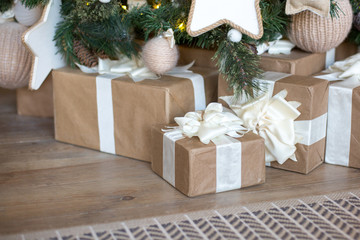 Naklejka na ściany i meble Many Christmas gift with a white bow of ribbons under the tree. Happy New Year mood