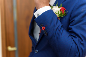 groom in a jacket, boutonniere on a jacket, the groom adjusts his jacket, The morning of the groom, business style, man in a jacket