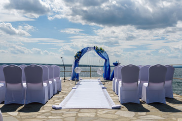 Wedding arch with empty chairs on the background of the lake