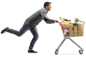 Guy running and pushing a shopping cart filled with groceries