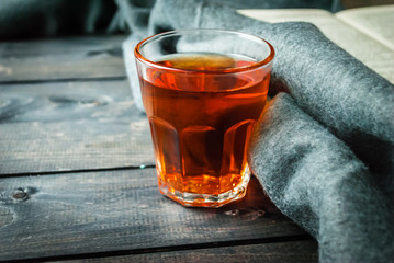 Tea, book and blanket on a wooden background