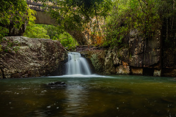 Fototapeta na wymiar Rainforest waterfall under a road bridge.
