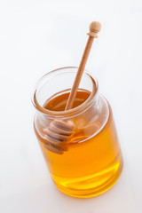 jar of honey with honeycomb on white