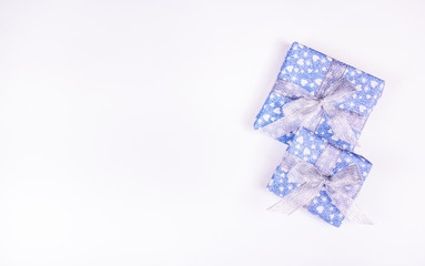 Blue gift boxes with silver bows on a white background. Celebratory concept. Brilliant boxes. Copy space
