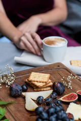Girl in dress drinks coffee with delicious food