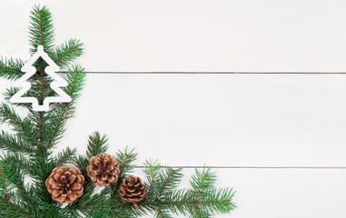 Christmas background with fir tree branches and decorative elements over white wooden surface. New year backdrop.