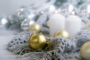 White holiday candles by silver toy, Happy New Year and knitted plaid rustic wooden background; holiday background with white copy space